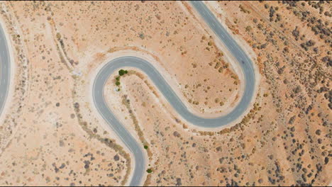 high altitude aerial view about a winding road somewhere in a desert area, america