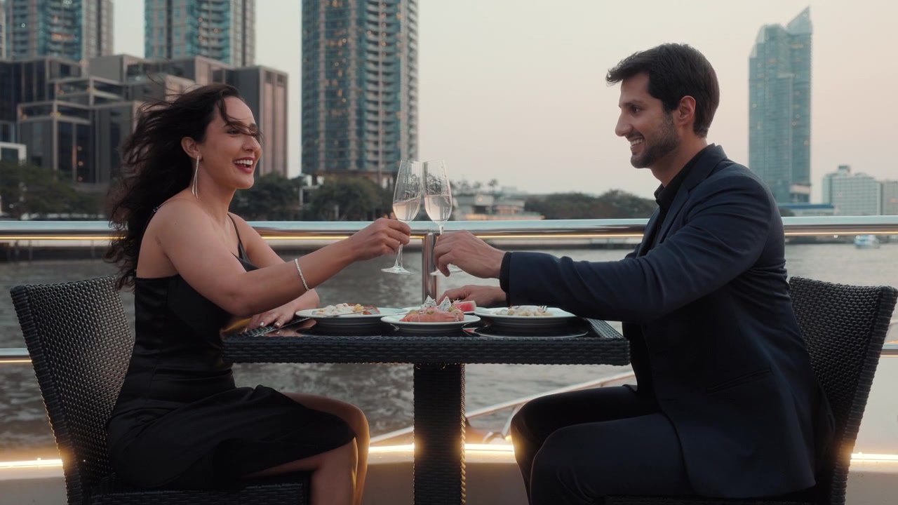 Coppia romantica che brinda con champagne durante una cena su una crociera cittadina
