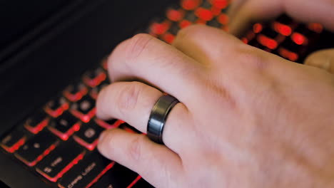 man begins typing on a laptop computer - viewed from side