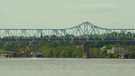 panning-to-the-left-on-a-long-blue-truss-bridge-in-Pennsylvania,-Monaca-East-Rochester-Bridge-on-the-Ohio-river