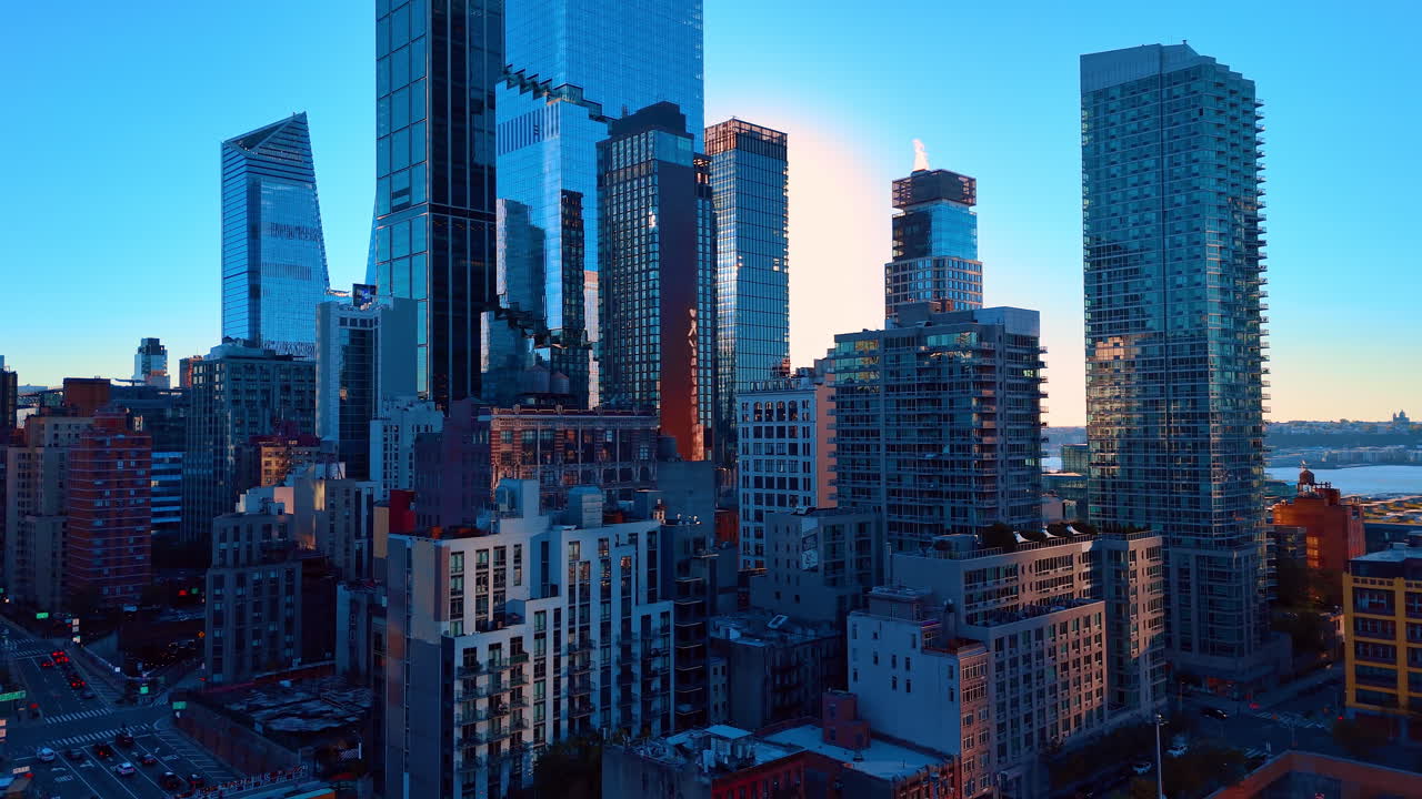 Grattacieli moderni in vetro al tramonto nel centro metropolitano della città. Edifici per uffici a molti piani con facciate in vetro riflettente durante l'ora d'oro, con vista sulla strada urbana sottostante.
