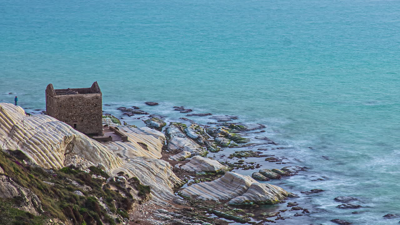 el lapso de tiempo en punta bianca y las ruinas de la guardia, orilla rocosa, sicilia