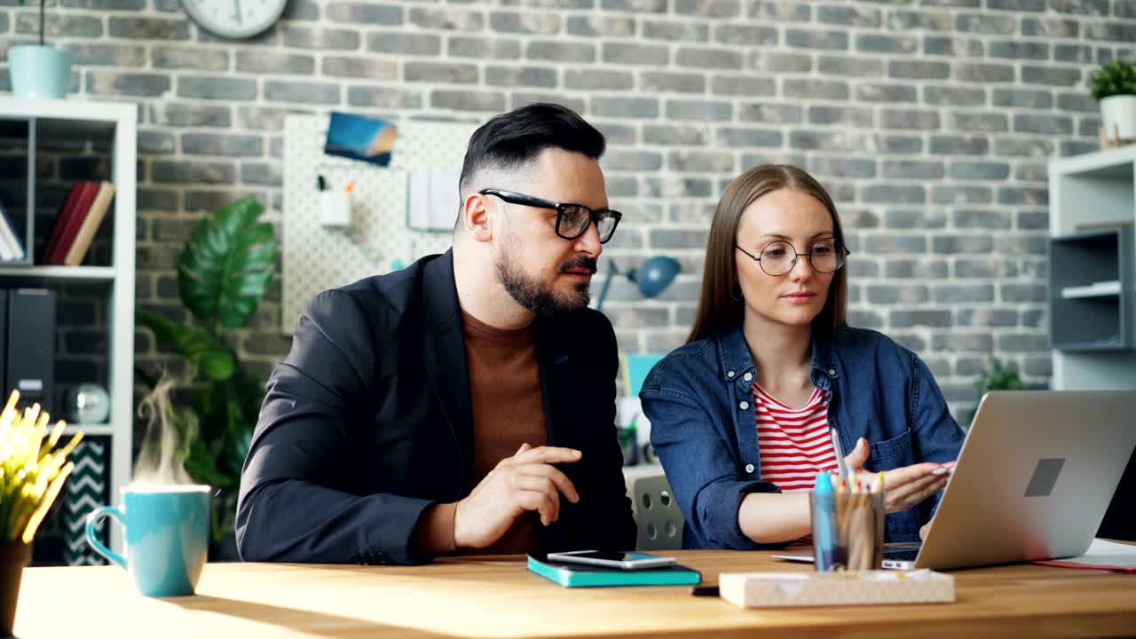 Endless loop of man and woman working with laptop while coffee cup steaming