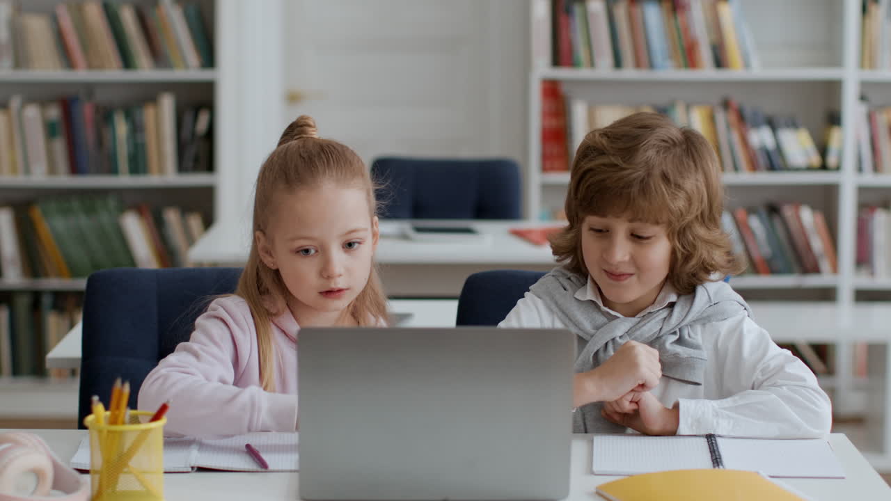 Children Studying Together on a Laptop in a Library
