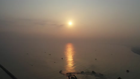 sunrise over the calm ocean with fishing boats