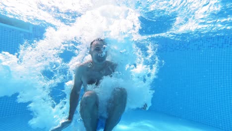 underwater view of man jumping in the pool, slow motion