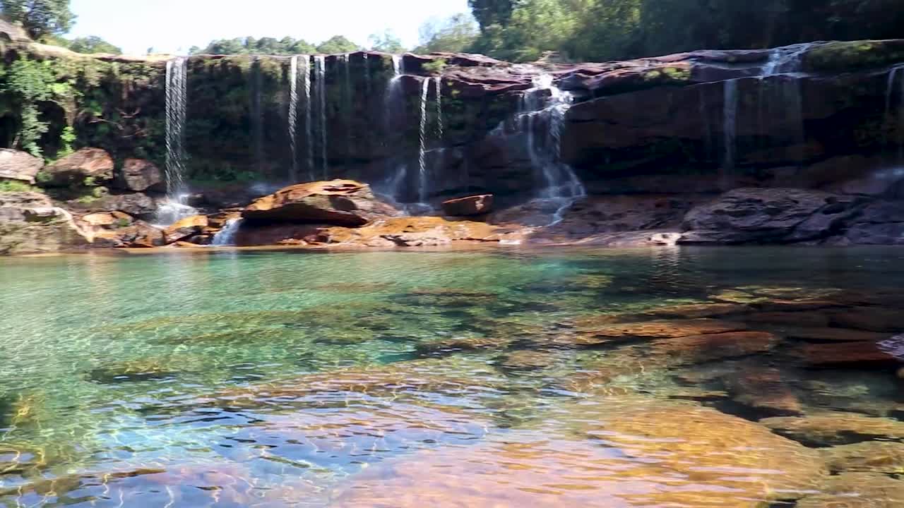 cascada natural que cae de la montaña en los bosques durante el día desde un ángulo plano