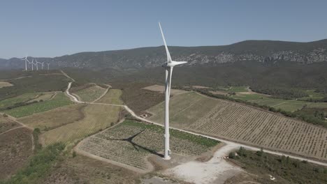 molinos de viento giran en vista aérea de los viñedos del valle en los pirineos franceses