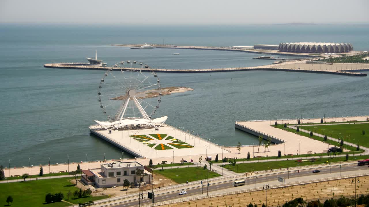 vista panorámica de la rueda de la ferris gira cerca del mar, el tráfico de automóviles en la carretera. baku, azerbaiyán. lapso de tiempo