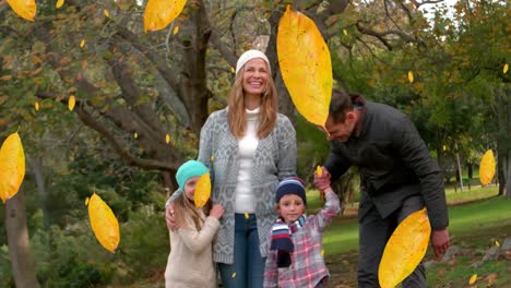 Animation-of-fall-leaves-falling-over-happy-caucasian-family-in-autumn-park