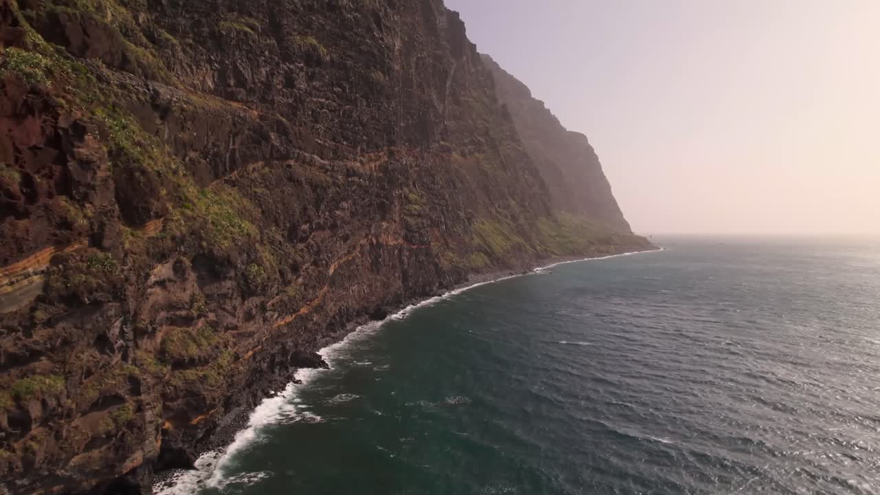 Metraje de dron de una montaña junto al mar en impresionante 4K, capturando acantilados dramáticos, el océano azul y una costa pintoresca. Perfecto para películas de viajes, documentales de naturaleza, proyectos cinematográficos y paisaje.