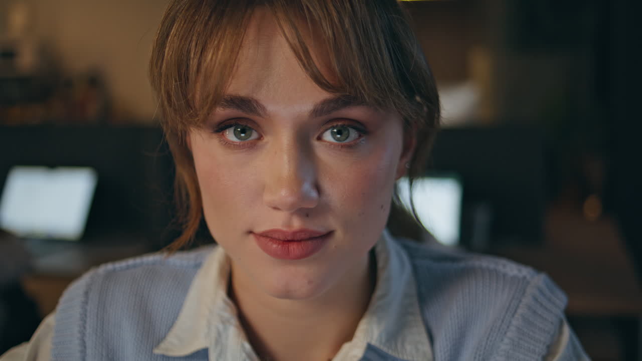 Late businesswoman working office closeup. Smiling young lady looking at camera