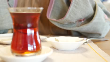 un primer plano de dos vasos de té turco en una mesa en un café