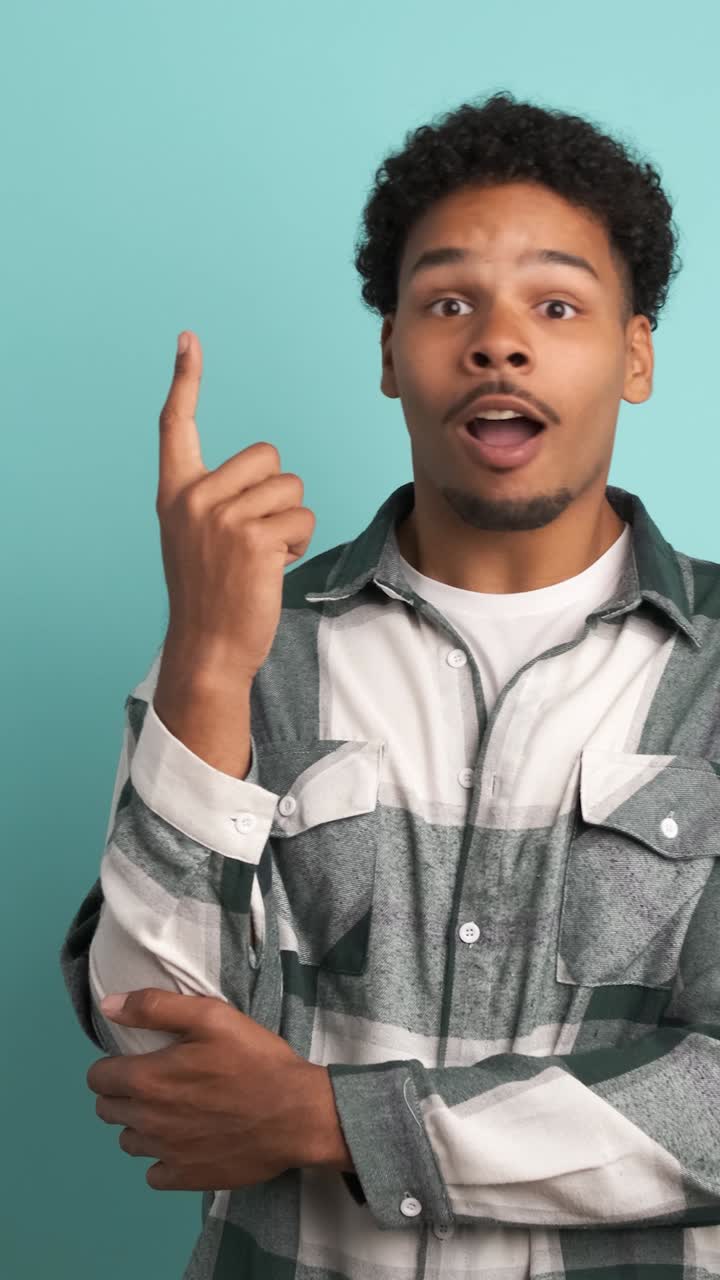 Thoughtful young man with great idea in blue studio