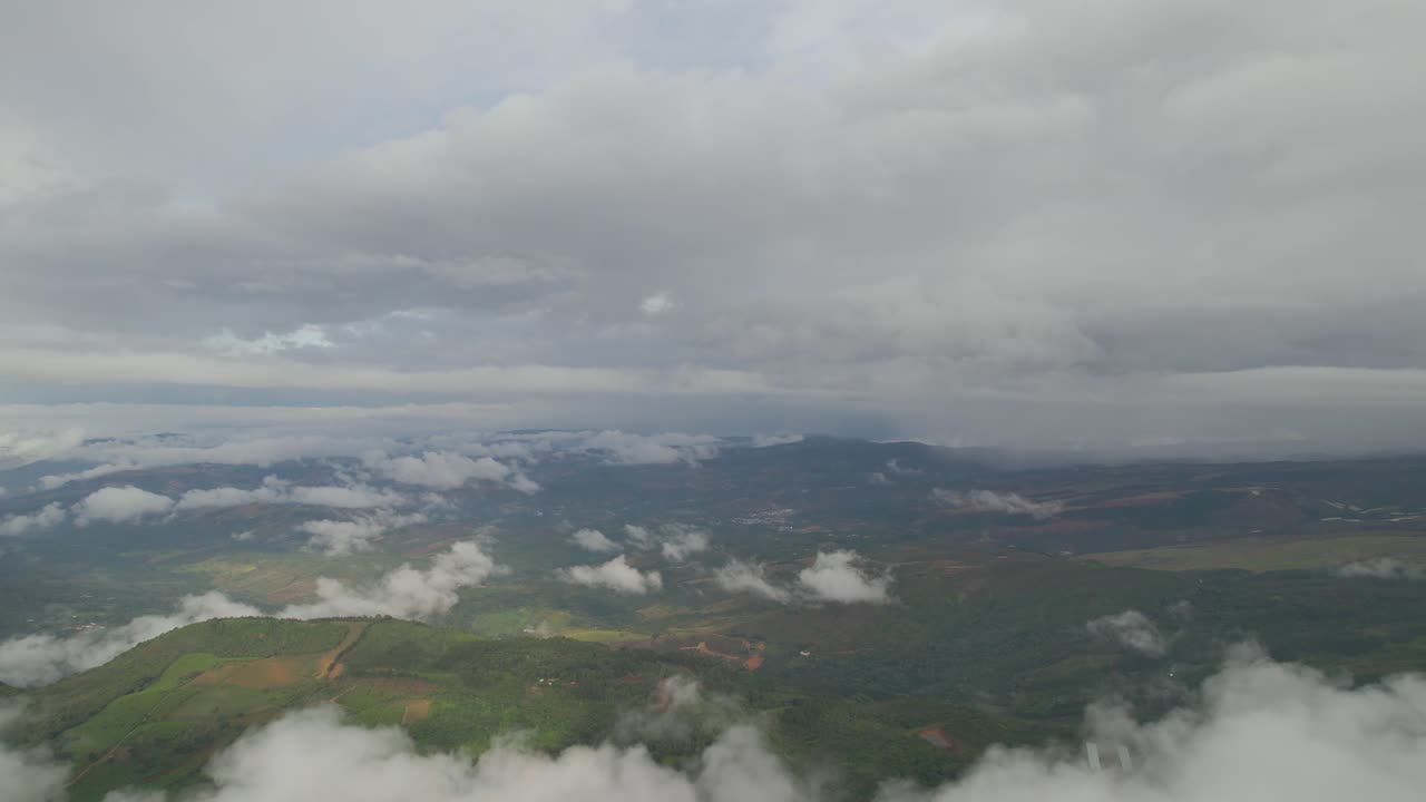 Dolly inn slowly with drone in over clouds with view of mountains at a foggy morning in Colombia