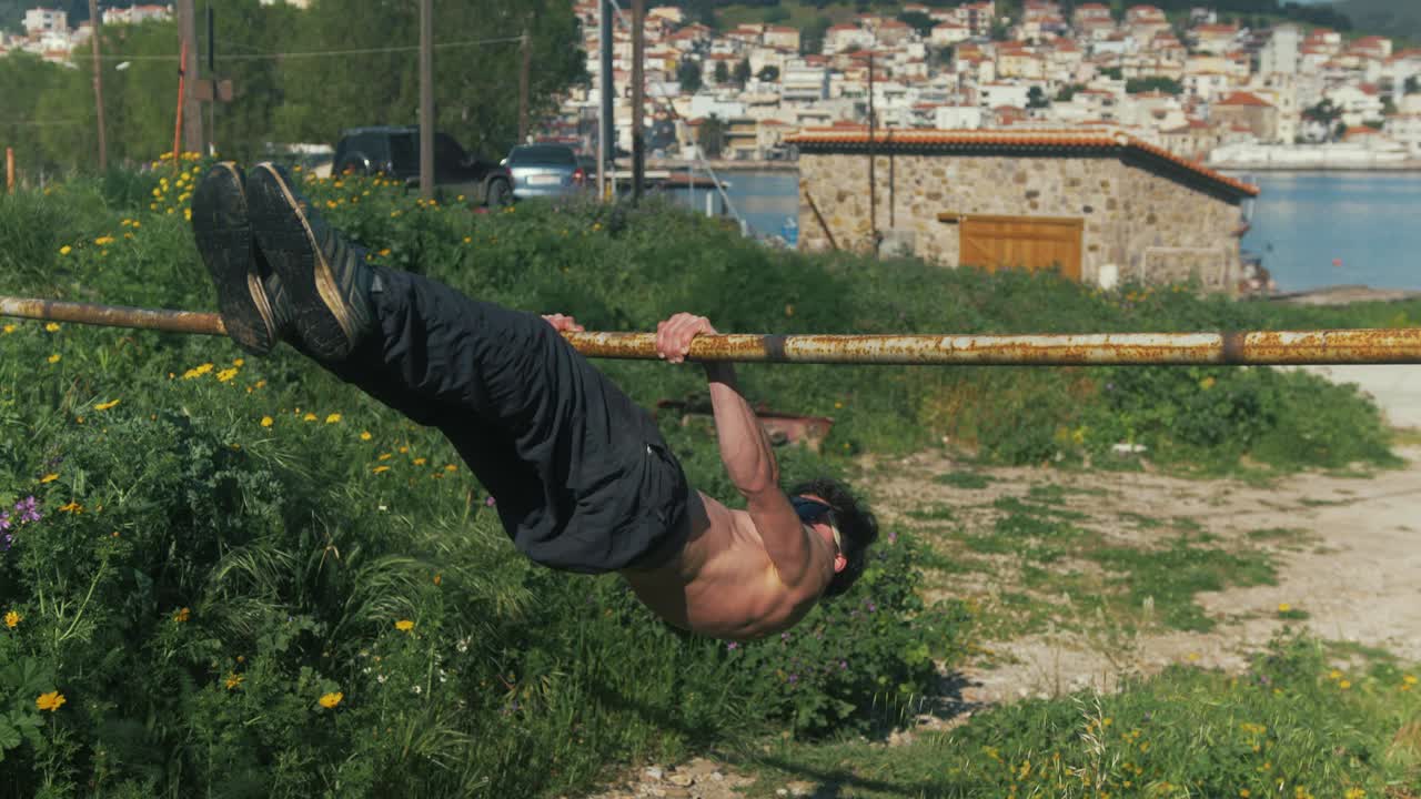 atlético joven varón entrena estático palanca delantera ejercicio gimnástico al aire libre sin camisa
