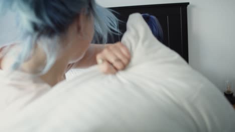 handheld video of lesbian couple have fun during pillow fight