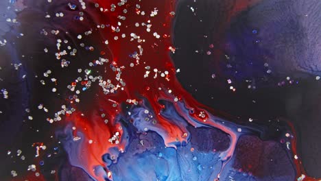 vibrant red and blue ink swirling in water with sparkling particles, an abstract fusion creating a mesmerizing effect