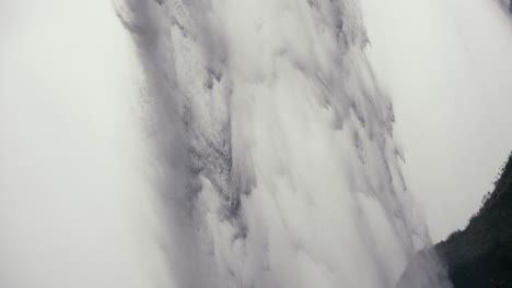 a powerful and epic stream of water falls over a rocky cliff