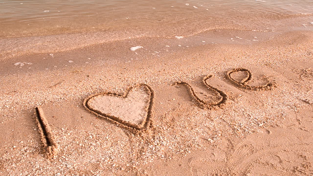 Inscription on sand. I love. Shooting on the beach