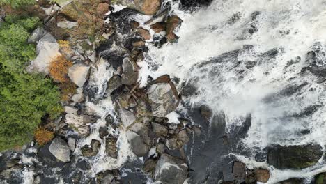 Top-down-aerial-shot-of-water-flowing-over-a-waterfall