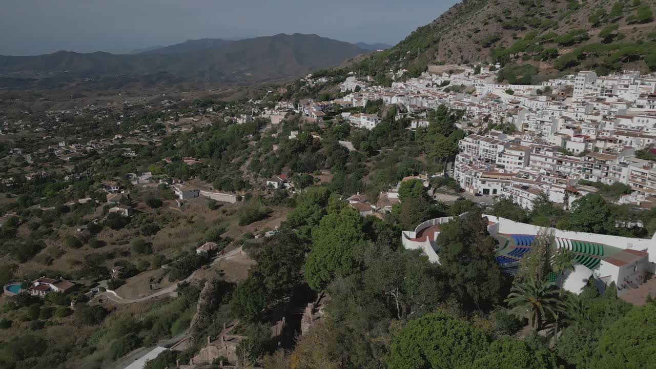 Villaggio di Mijas con edifici bianchi adagiati su una collina, giornata di sole, vista aerea