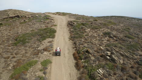 Couple-off-road-quad-biking,-ATV-on-the-island-of-Ios,-Greece,-on-a-rough-dirt-track