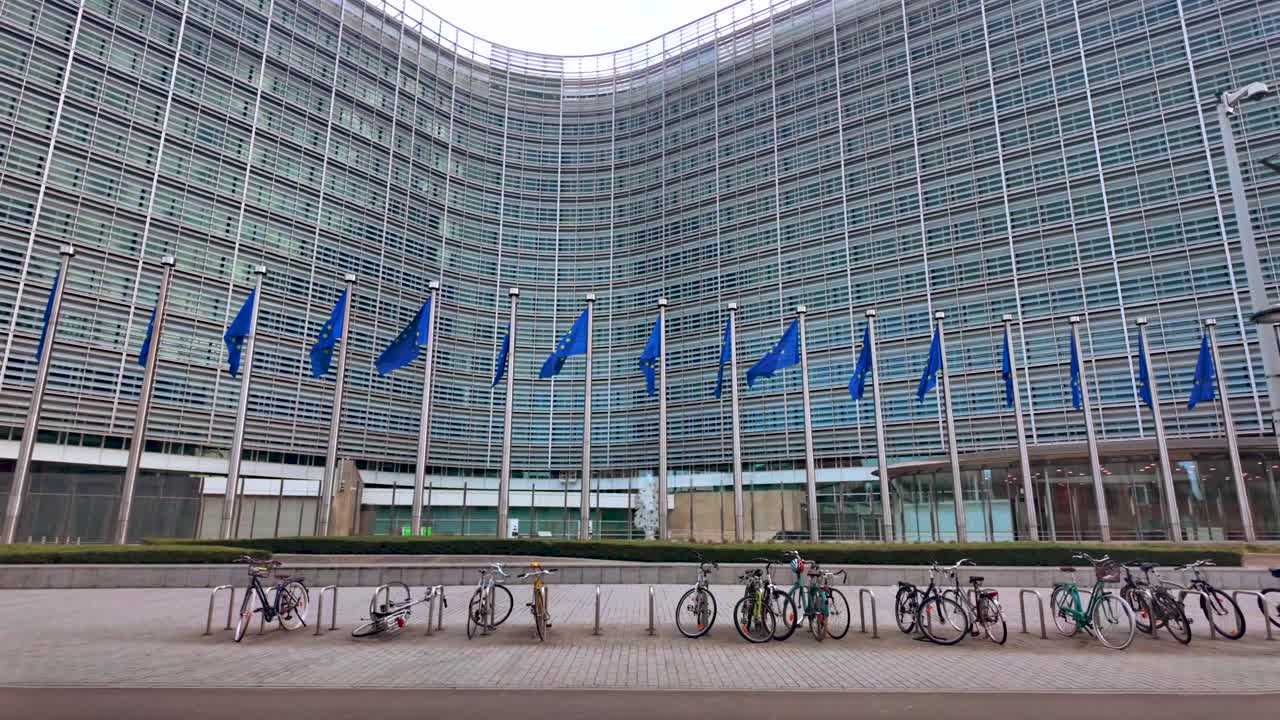 Slow motion EU flags waving outside Commission with bikes in foreground