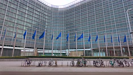 slow motion eu flags waving outside commission with bikes in foreground