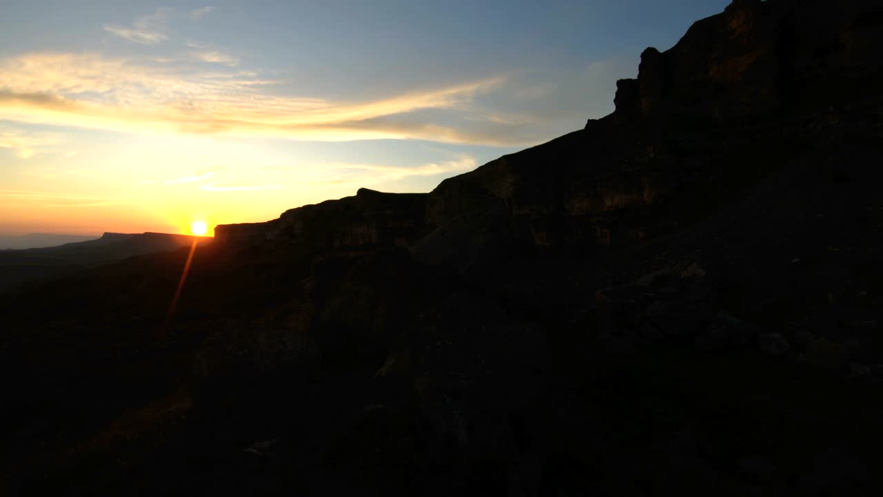 puesta de sol en la montaña sobre la roca pico. clave oscura puesta de sol luz en las montañas paralaje rocas hierba de roca