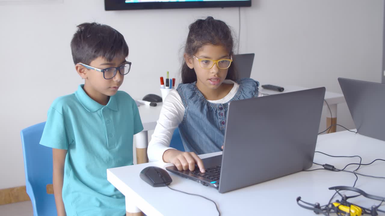 два серьезных одноклассника в очках, работающих над задачей