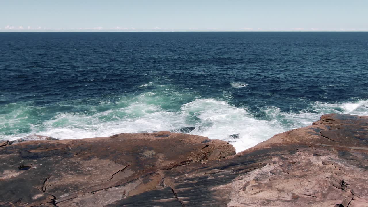 olas del océano rompiendo en el paseo marítimo rocoso en la playa de agua dulce en el estado australiano de nueva gales del sur