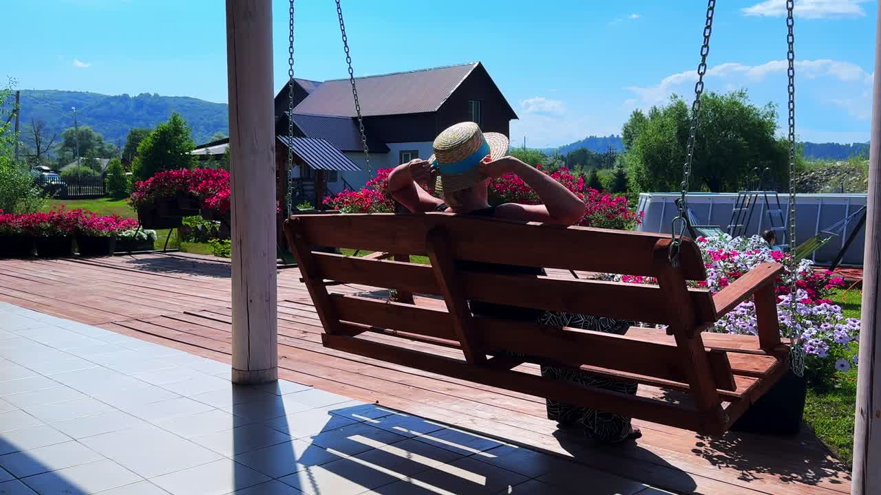 Relaxation in Nature: A Serene Scene of a Person Enjoying a Scenic Swing in a Colorful Garden under a Clear Blue Sky
