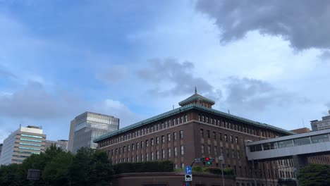 a historical building in yokohama city surrounded by modern skyscrapers and greenery