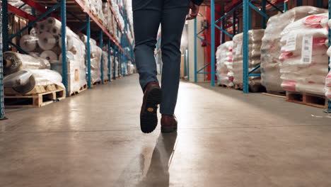 a man in a blue suit walks through a warehouse