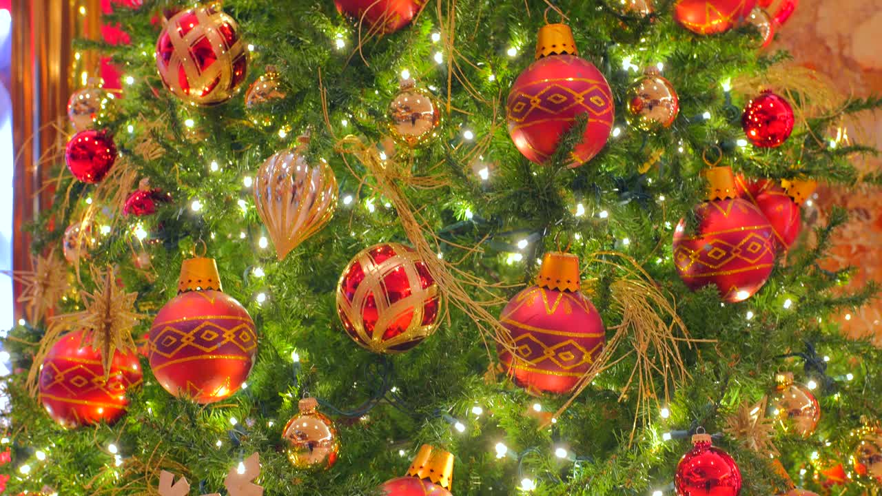 hermosos y elegantes adornos navideños colgando del árbol con luces brillantes