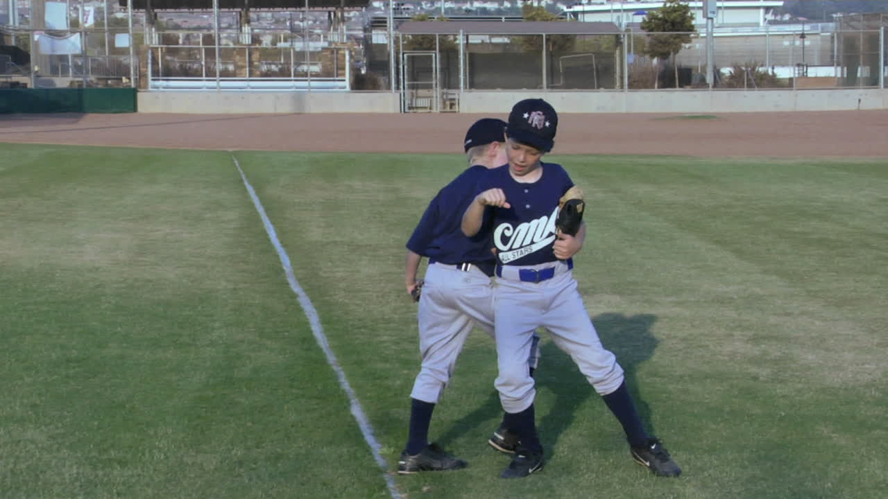 리틀 리그 야구 선수들이 서로 장난스럽게 악수를 주고받다