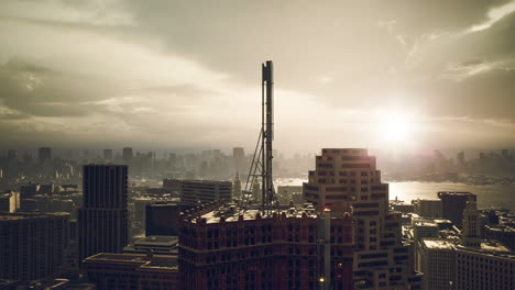 sunset over a sprawling city skyline with a communication tower in view