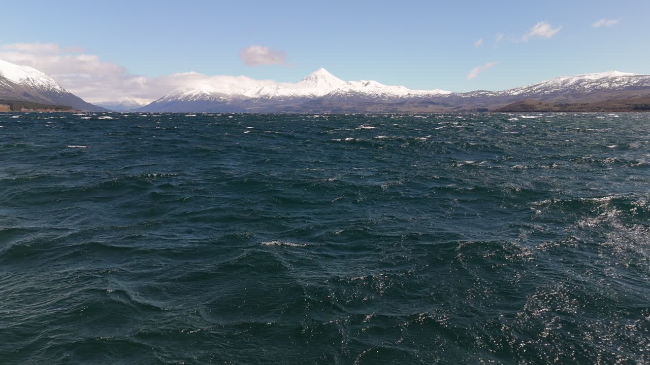 Flying over Huechulafquen lake towards snow covered Lanín Volcano in Patagonia, Neuquén, Argentina