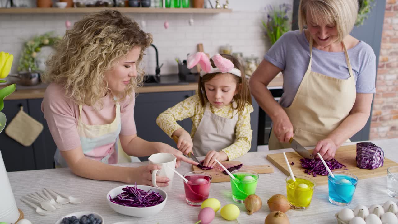 Tracking video of three generations of women in the kitchen