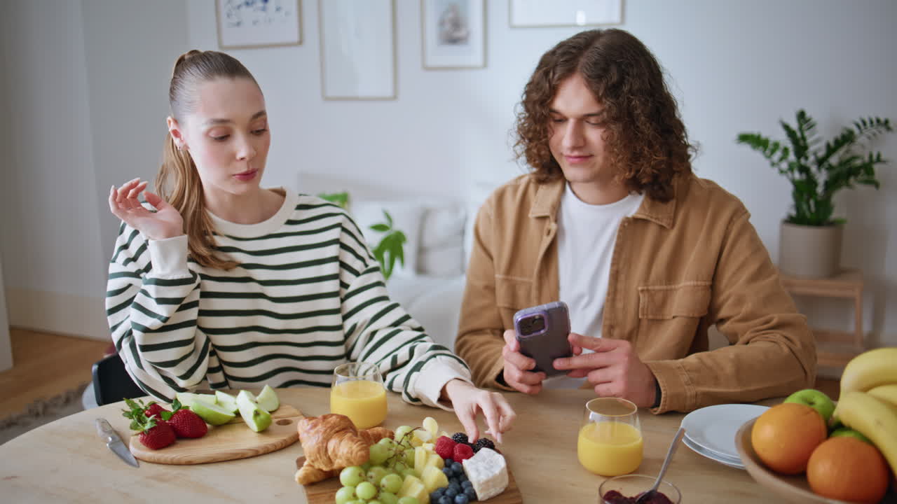 Loving wife feeding husband with grape in home apartment closeup. Smiling woman