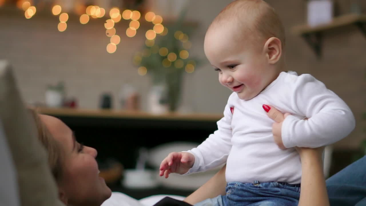행복한 가족. 엄마가 침실에서 아기와 놀고. 웃고 미소 짓고.