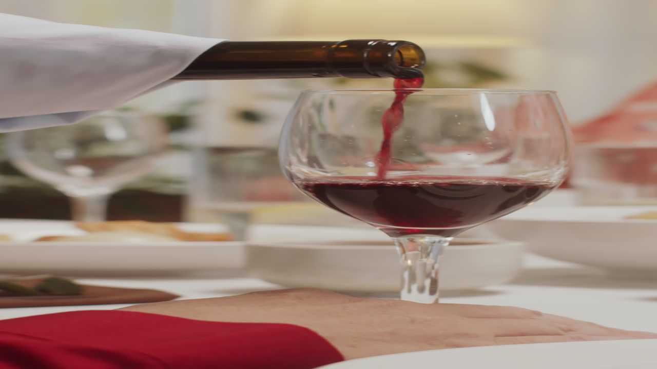 Hombre sirviendo vino tinto en una copa