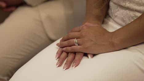 bride's hands resting on her lap, displaying her wedding ring