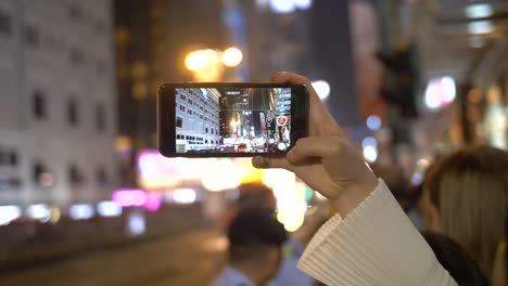 pessoa filmando desfile em smartphone