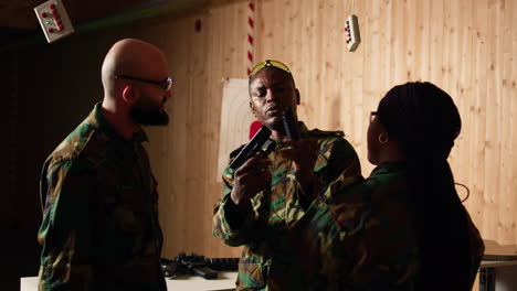 military officer instructing soldiers on how to load ammunition into pistol