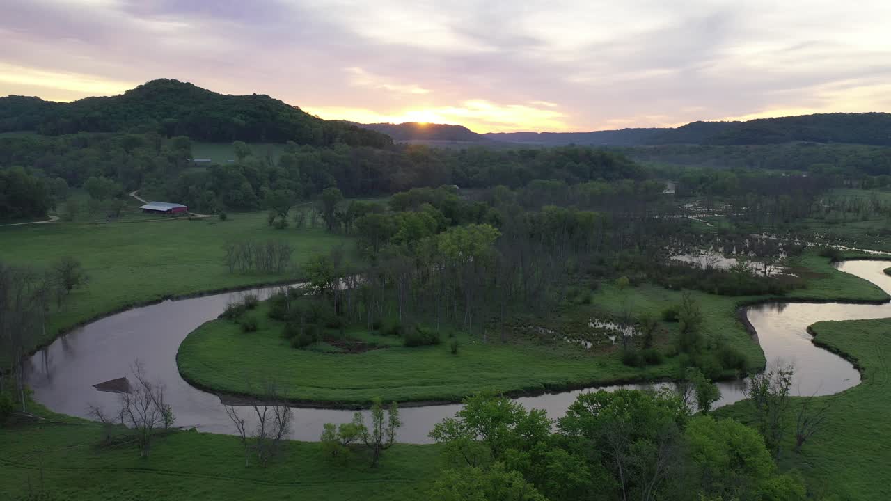 amanecer sobre un valle rural con río y tierras de cultivo