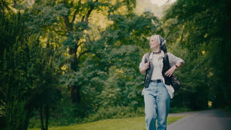 carefree woman with camera exploring forest