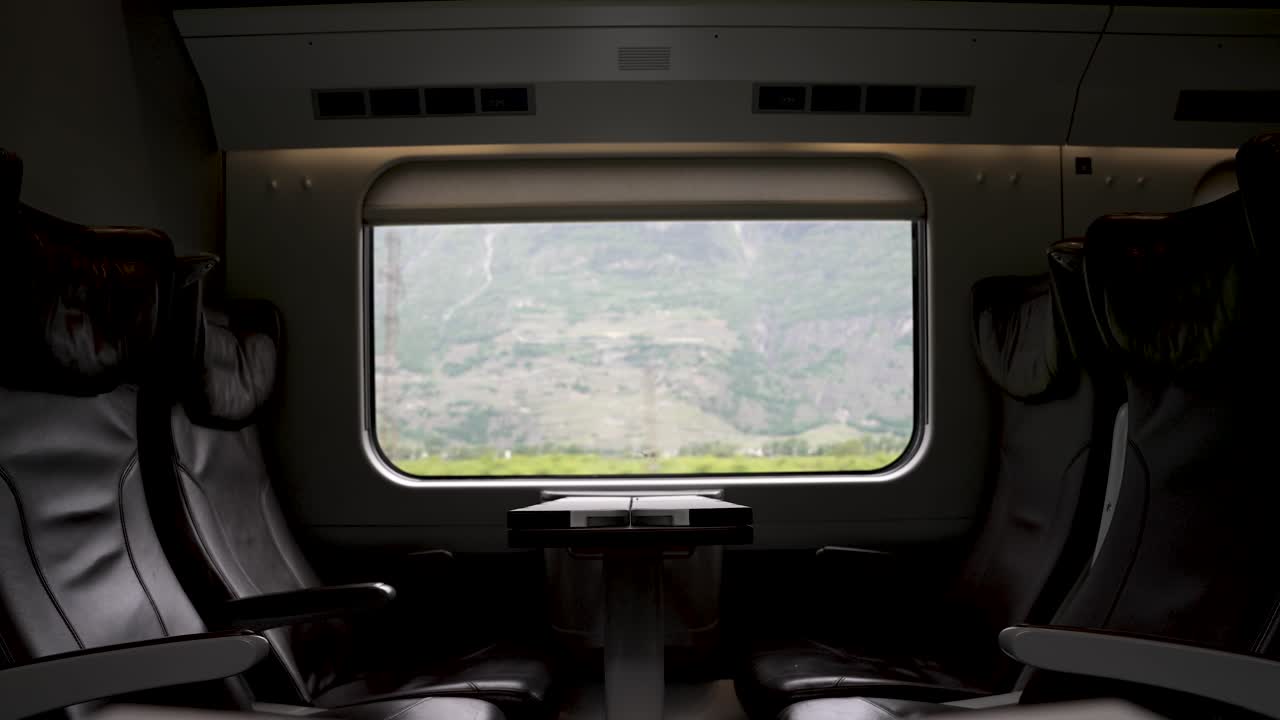 Una carrozza ferroviaria vuota di business class con una vista panoramica della campagna svizzera che scorre dal finestrino, Svizzera