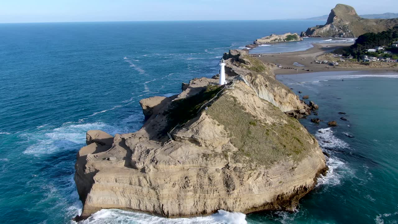 faro que sirve como baliza de seguridad de navegación en la costa de nueva zelanda - vista giratoria aérea